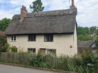 George Orwells house in the village of Wallington.  It has a thatched roof and is painted a light beige colour